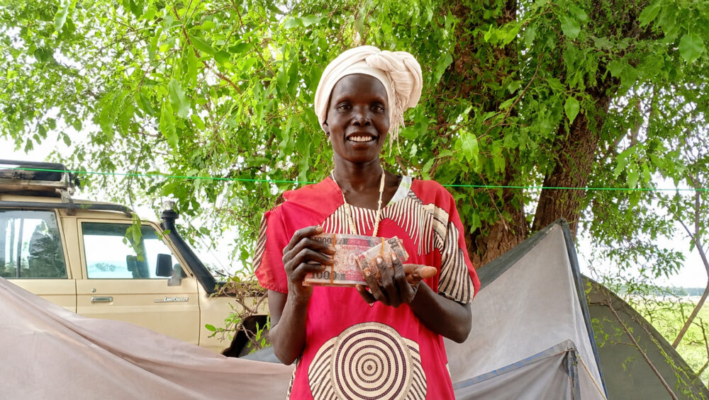 Elizabeth poses with the cash received during the second cash assistance distribution by ForAfrika in Majak Ajuong Finding new strength through cash assistance