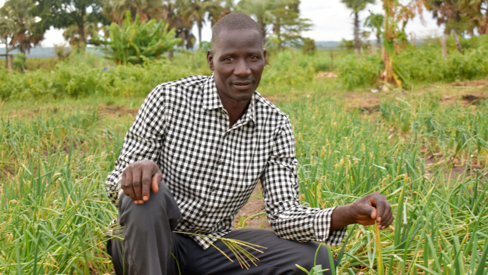 Tiondi Isaac, Group Chairperson, Giant Farmers Group, showcasing their onion field. Thanks to ForAfrika’s support, the group is expecting to earn over UGX 20 million (approximately USD 540) after harvest.